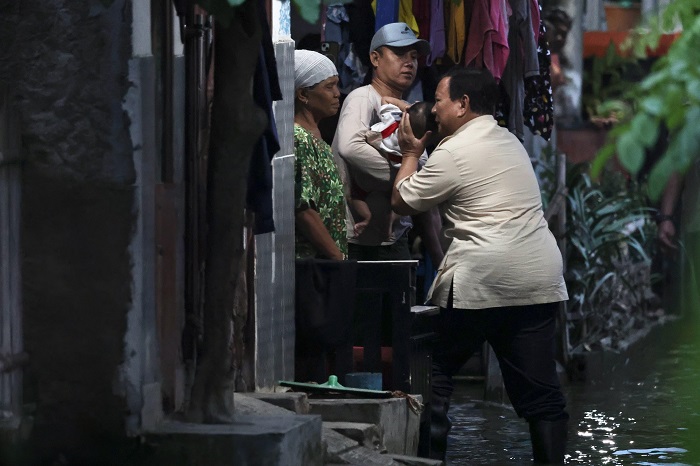 Presiden RI Prabowo Subianto menelepon sejumlah pejabat saat mengecek langsung kondisi warga terdampak banjir di Kampung Tambun Inpres. (Dok. Tim Media Prabowo)